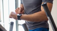 Fitter Mann, der Technologie verwendet, um seine Fitness zu verfolgen, um seine Vorsätze einzuhalten