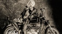Muskulöse Frau Shelley Beattie neben einem Harley-Davidson-Motorrad