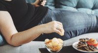 Schweres-Weibchen-Essen-Chips-Kekse-auf-der-Couch