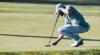 Golfspieler, der die Lüge auf dem Grün aufbaut