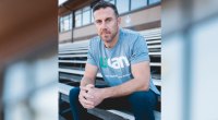 NFL Kansas City Chiefs Quarterback Alex Smith sitzt auf der Tribüne und trägt ein UCAN-T-Shirt