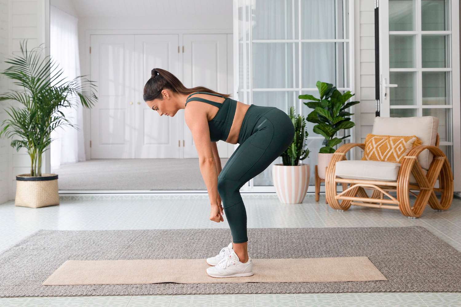 Frau im grünen Trainingsset, das einen Kreuzheben tut